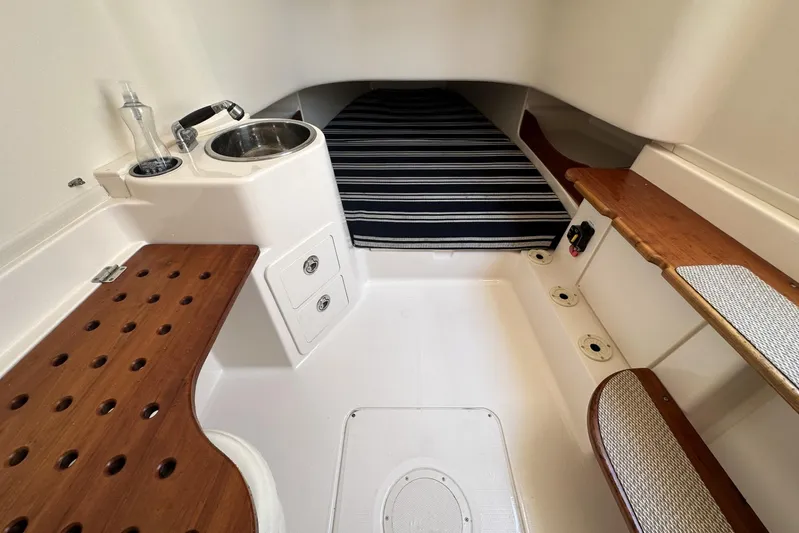  Yacht Photos Pics 2014 Grady-White Canyon 336 cabin interior with sink, striped bedding, and wooden accents.