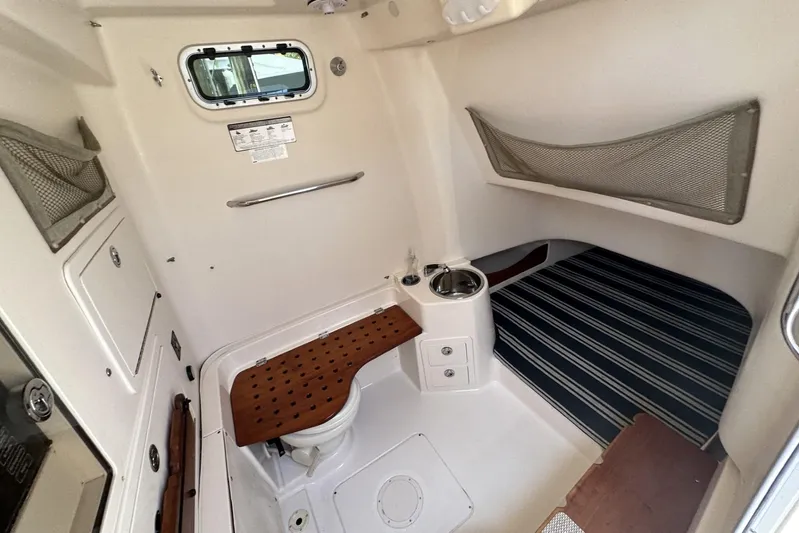  Yacht Photos Pics 2014 Grady-White Canyon 336 cabin interior with striped bedding and compact amenities.