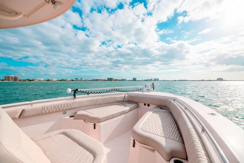  Yacht Photos Pics 2014 Grady-White Canyon 336 boat on serene water with city skyline and cloudy sky.