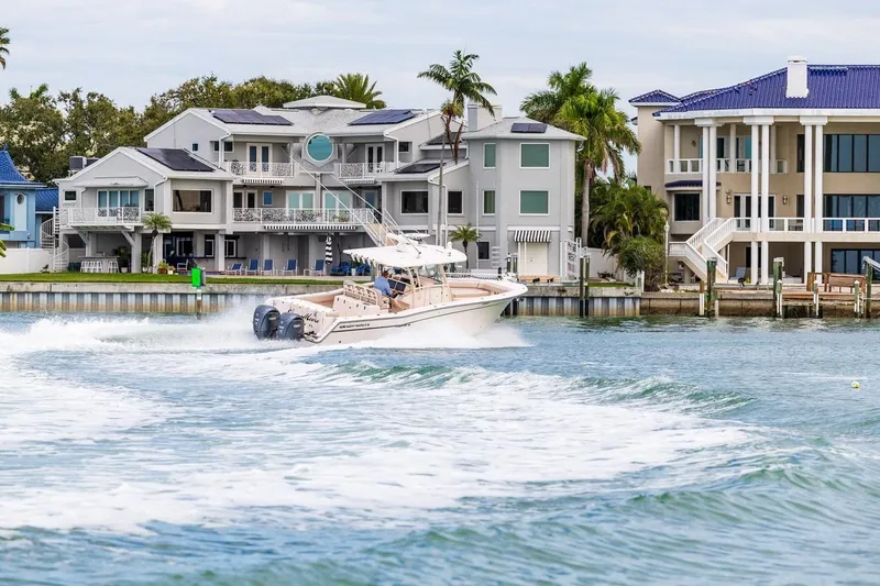  Yacht Photos Pics 2014 Grady-White Canyon 336 boat cruising near luxury waterfront homes.