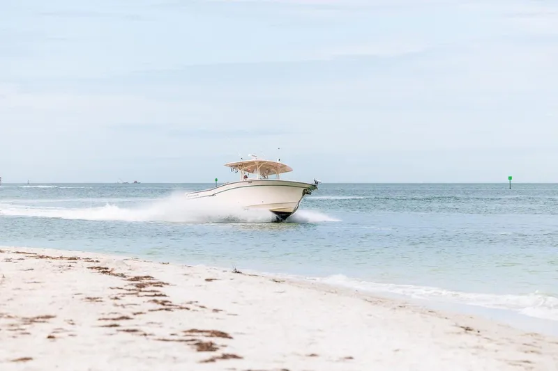  Yacht Photos Pics 2014 Grady-White Canyon 336 boat cruising near sandy beach.