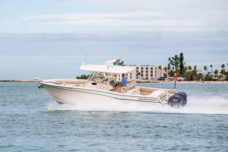  Yacht Photos Pics 2014 Grady-White Canyon 336 boat cruising on water with scenic background.
