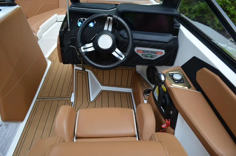  Yacht Photos Pics 2023 Nautique Super Air Nautique S23 boat interior with brown seating and modern dashboard.
