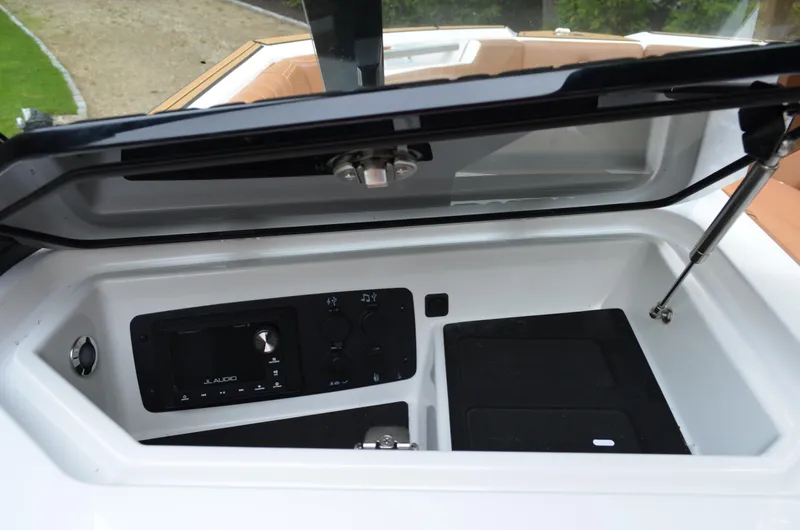  Yacht Photos Pics 2023 Nautique Super Air Nautique S23 storage compartment with audio controls and sleek design.