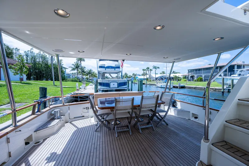 Pivot Yacht Photos Pics 2013 Marlow Explorer Enclosed Bridge yacht deck with dining area and waterfront view.