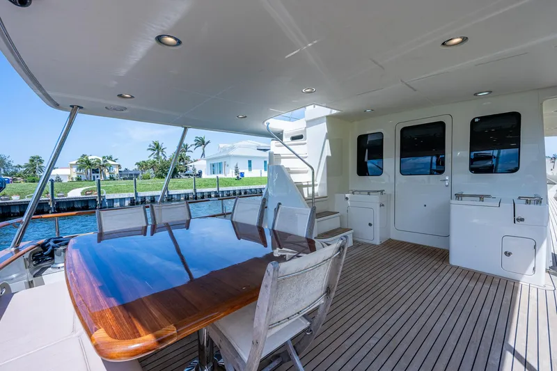 Pivot Yacht Photos Pics 2013 Marlow Explorer Enclosed Bridge CB yacht with outdoor dining area and waterfront view.