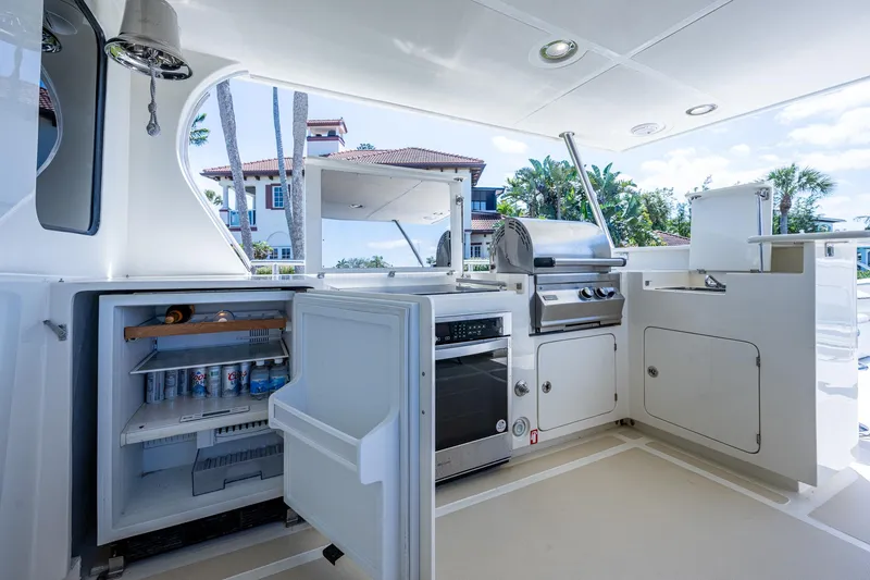 Pivot Yacht Photos Pics Outdoor kitchen on 2013 Marlow Explorer Enclosed Bridge yacht with grill, fridge, and storage.