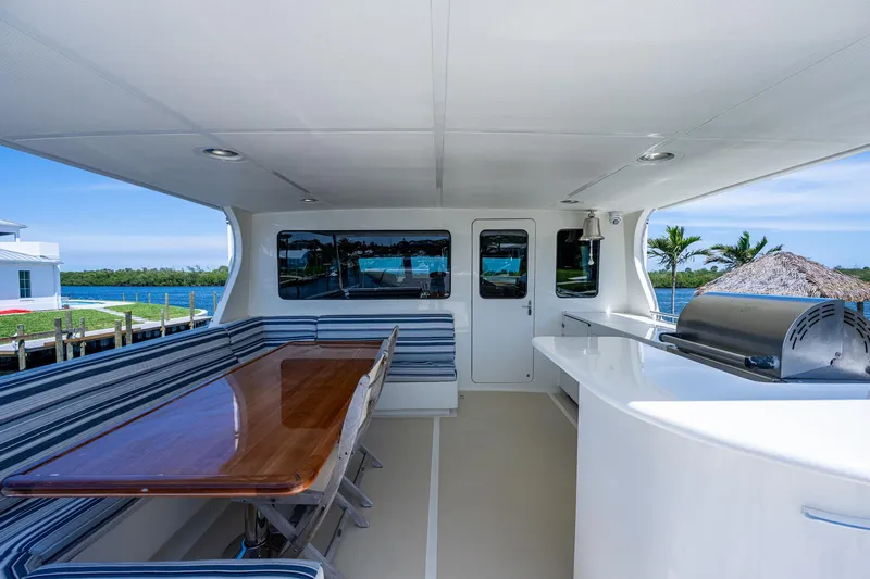 Pivot Yacht Photos Pics 2013 Marlow Explorer Enclosed Bridge (CB) yacht interior with dining area and outdoor grill.