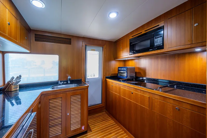 Pivot Yacht Photos Pics 2013 Marlow Explorer Enclosed Bridge (CB) yacht kitchen with wooden cabinetry and modern appliances.