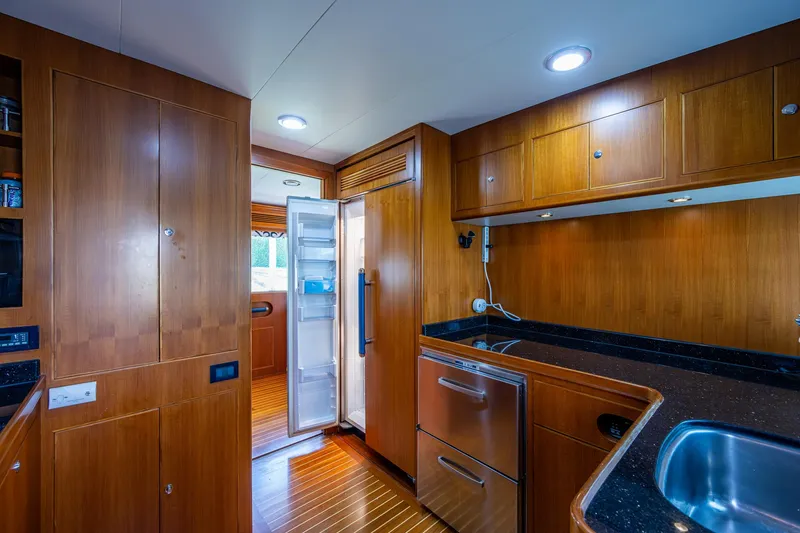 Pivot Yacht Photos Pics 2013 Marlow Explorer Enclosed Bridge (CB) yacht kitchen with wooden cabinetry and modern appliances.