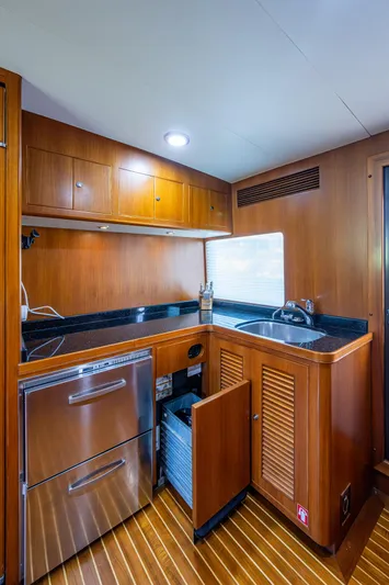 Pivot Yacht Photos Pics 2013 Marlow Explorer Enclosed Bridge CB yacht kitchen with stainless steel appliances and wooden cabinetry.