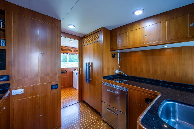 Pivot Yacht Photos Pics 2013 Marlow Explorer Enclosed Bridge CB yacht kitchen with wooden cabinetry and modern appliances.