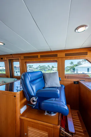 Pivot Yacht Photos Pics 2013 Marlow Explorer Enclosed Bridge (CB) with blue captain's chair and wooden interior.