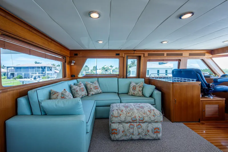 Pivot Yacht Photos Pics Interior of 2013 Marlow Explorer Enclosed Bridge (CB) with blue sofa and patterned ottoman.