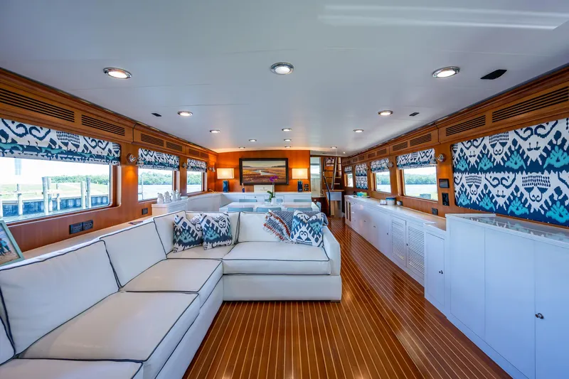 Pivot Yacht Photos Pics Luxurious interior of 2013 Marlow Explorer Enclosed Bridge yacht with white sofas and wooden flooring.