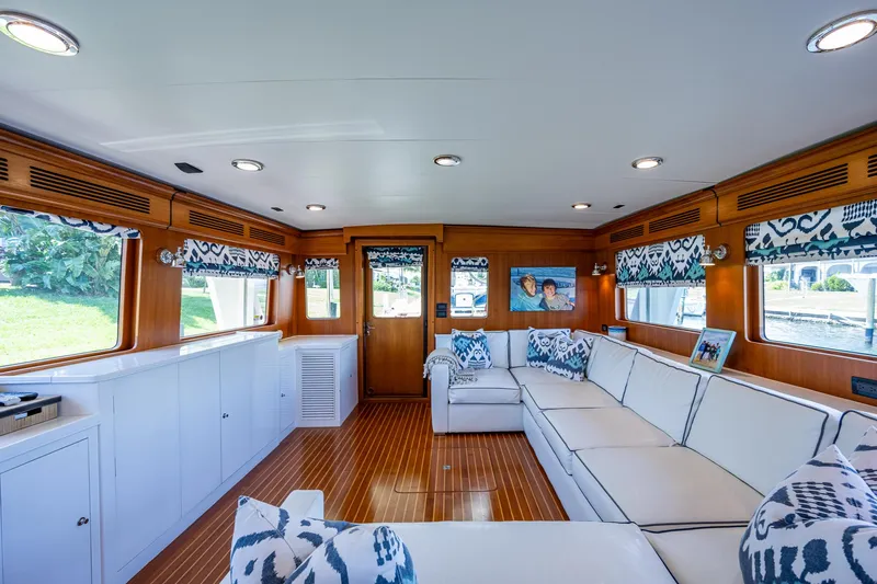 Pivot Yacht Photos Pics Luxurious interior of 2013 Marlow Explorer Enclosed Bridge yacht with white seating and wooden accents.