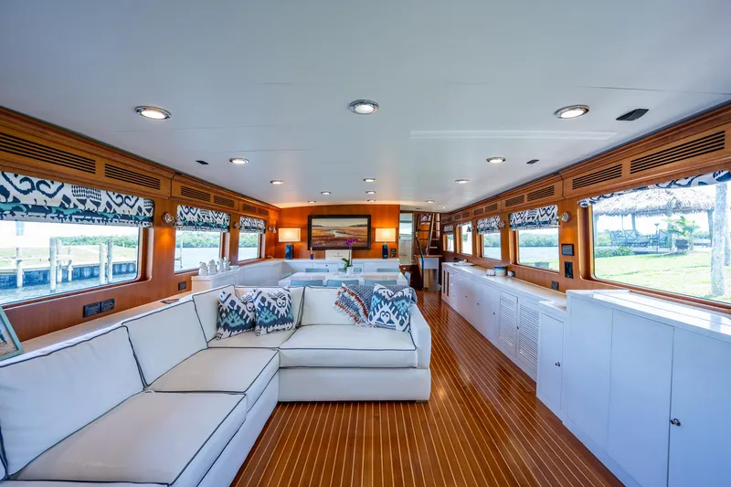 Pivot Yacht Photos Pics Luxurious interior of 2013 Marlow Explorer Enclosed Bridge yacht with white sofas and wooden flooring.