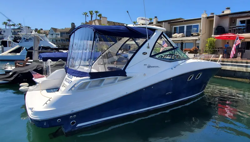 Just Becuz Yacht Photos Pics 2007 Sea Ray 310 Sundancer docked in a marina, featuring a sleek blue and white design.