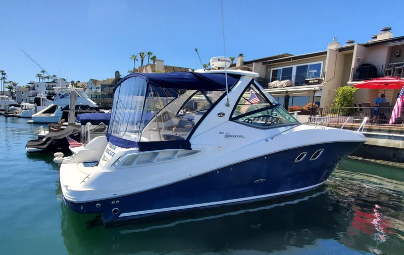 Just Becuz Yacht Photos Pics 2007 Sea Ray 310 Sundancer boat docked in a marina, featuring a sleek blue and white design.