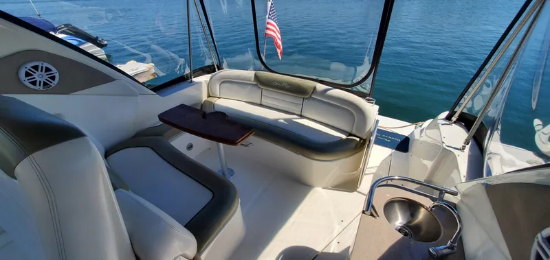 Just Becuz Yacht Photos Pics 2007 Sea Ray 310 Sundancer interior with seating, table, and American flag on calm water.
