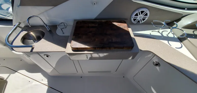 Just Becuz Yacht Photos Pics 2007 Sea Ray 310 Sundancer boat kitchenette with sink, cutting board, and cup holders.