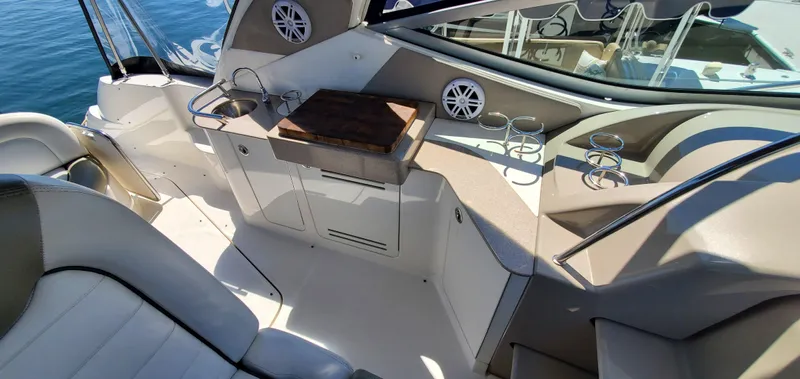 Just Becuz Yacht Photos Pics 2007 Sea Ray 310 Sundancer cockpit with seating, sink, and cup holders on a sunny day.