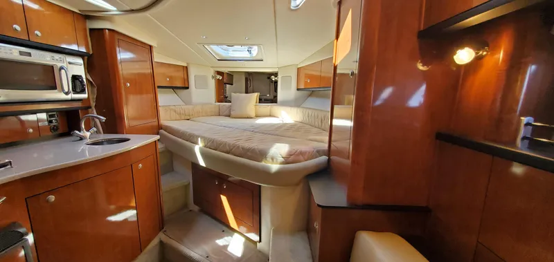 Just Becuz Yacht Photos Pics Luxurious interior of 2007 Sea Ray 310 Sundancer yacht with cozy bed and kitchenette.