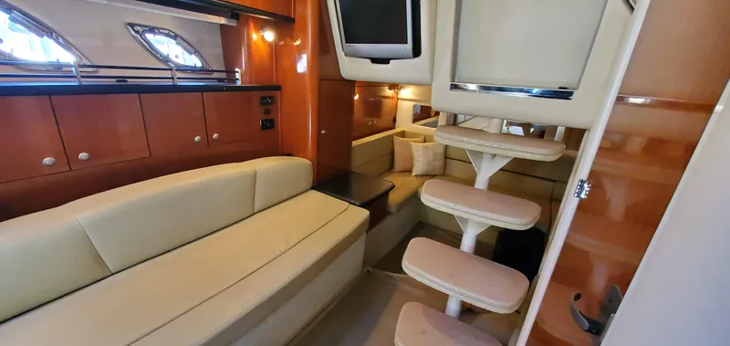 Just Becuz Yacht Photos Pics Interior of 2007 Sea Ray 310 Sundancer yacht with beige seating and wooden cabinetry.