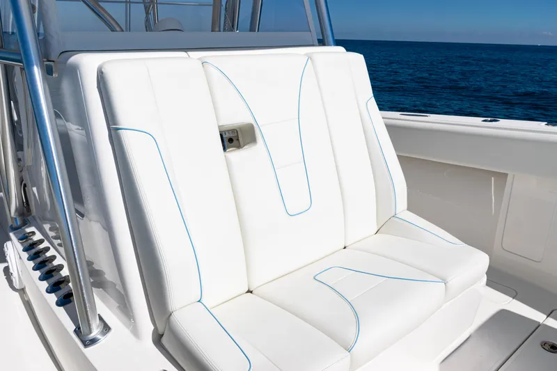  Yacht Photos Pics 2024 SeaVee 390B boat with white cushioned seating, blue stitching, and ocean backdrop.