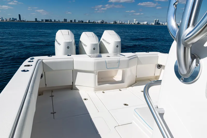  Yacht Photos Pics 2024 SeaVee 390B boat deck with triple Mercury engines, ocean view, and city skyline.