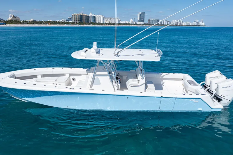  Yacht Photos Pics 2024 SeaVee 390B boat on clear blue water with city skyline in background.