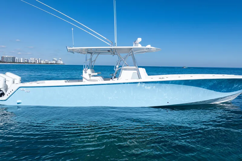  Yacht Photos Pics 2024 SeaVee 390B boat on calm ocean with city skyline in background.