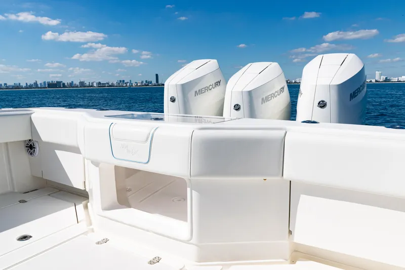  Yacht Photos Pics 2024 SeaVee 390B boat with Mercury engines, ocean view, and city skyline in background.
