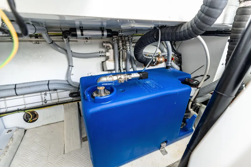 Mana Yacht Photos Pics Engine compartment of a 2025 Maori m54, featuring a blue fuel tank and various hoses.