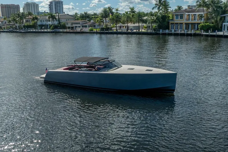 L.o.u. Yacht Photos Pics Luxurious 2016 VanDutch 55 yacht cruising on a serene waterfront with palm trees and houses.