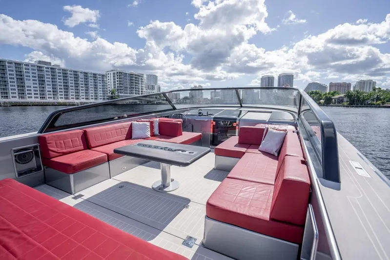L.o.u. Yacht Photos Pics Luxurious 2016 VanDutch 55 yacht with red seating, cruising near waterfront buildings.