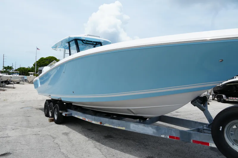  Yacht Photos Pics 2025 Fountain 38 CC boat in light blue on a trailer, parked outdoors.