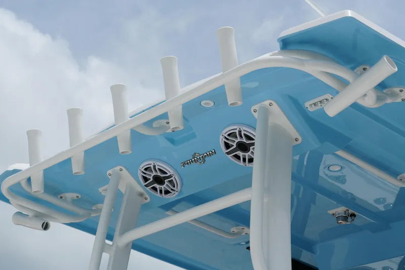  Yacht Photos Pics 2025 Fountain 38 CC boat with blue hull, rod holders, and speakers against a cloudy sky.