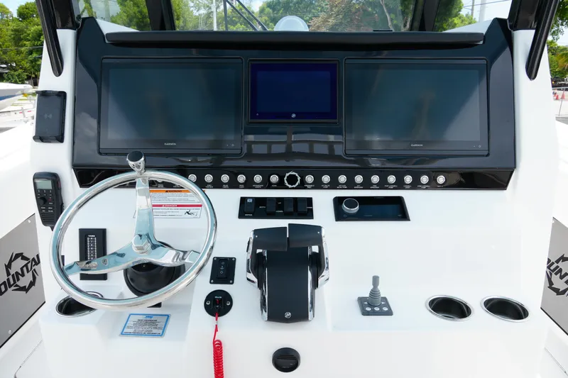  Yacht Photos Pics 2025 Fountain 38 CC boat dashboard with steering wheel and electronic displays.
