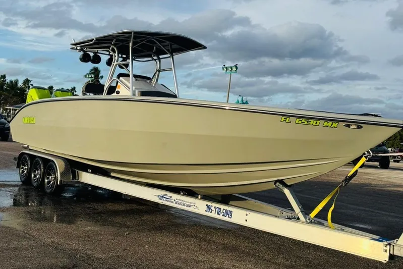  Yacht Photos Pics 2005 Carrera Boats 32 on trailer, parked outdoors under cloudy sky.