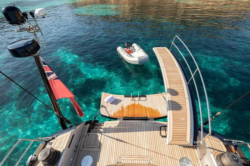 Caiarossa Yacht Photos Pics Luxury Shipman 72 yacht deck with tender boat on clear turquoise water, 2009 model.