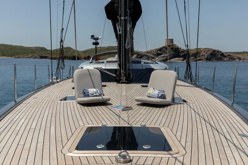 Caiarossa Yacht Photos Pics Luxurious 2009 Shipman 72 yacht deck with cushions, scenic coastal backdrop.