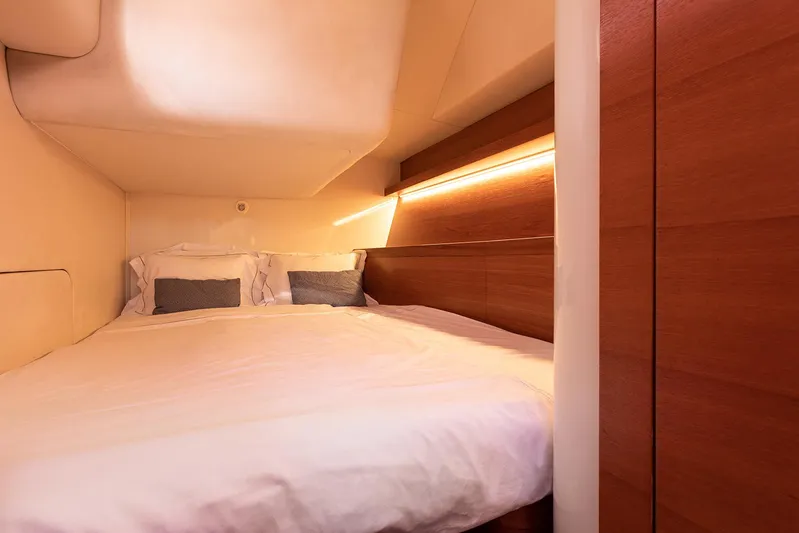 Caiarossa Yacht Photos Pics Luxurious cabin interior of 2009 Shipman 72 yacht with cozy bed and warm lighting.