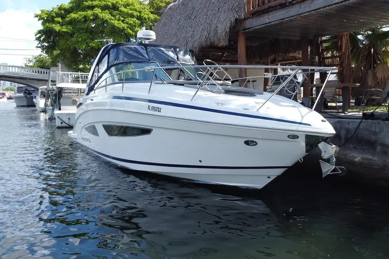 Panacea Yacht Photos Pics 2015 Regal 32 Express boat docked by a waterfront with lush greenery.