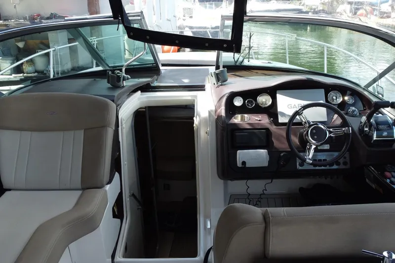 Panacea Yacht Photos Pics 2015 Regal 32 Express boat cockpit with steering wheel and navigation equipment.