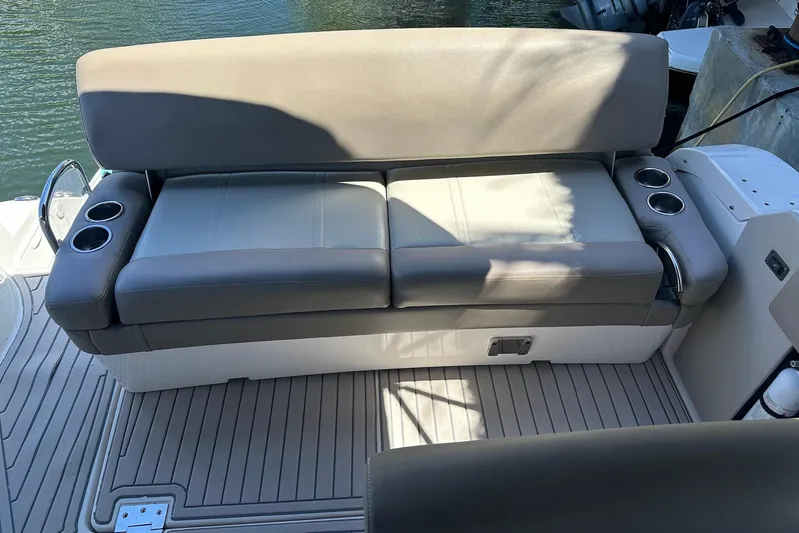 Panacea Yacht Photos Pics 2015 Regal 32 Express boat seating with cup holders, docked by the water.