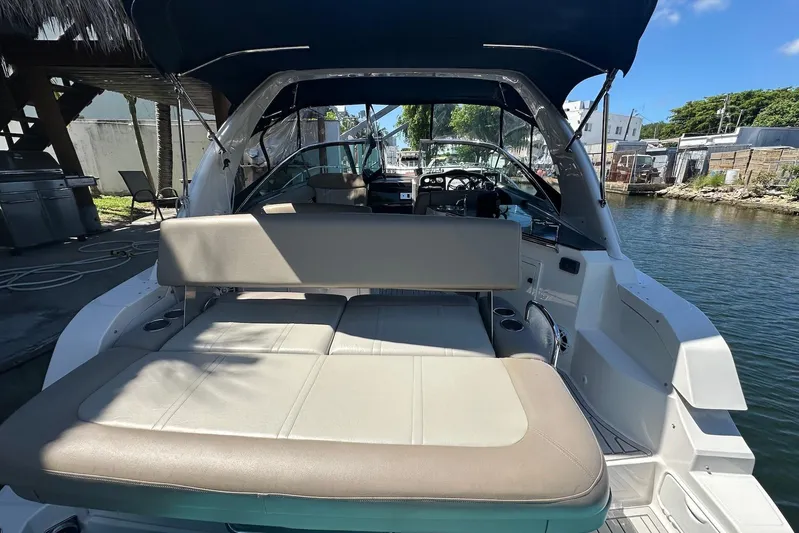 Panacea Yacht Photos Pics 2015 Regal 32 Express boat with spacious seating, docked by the water.