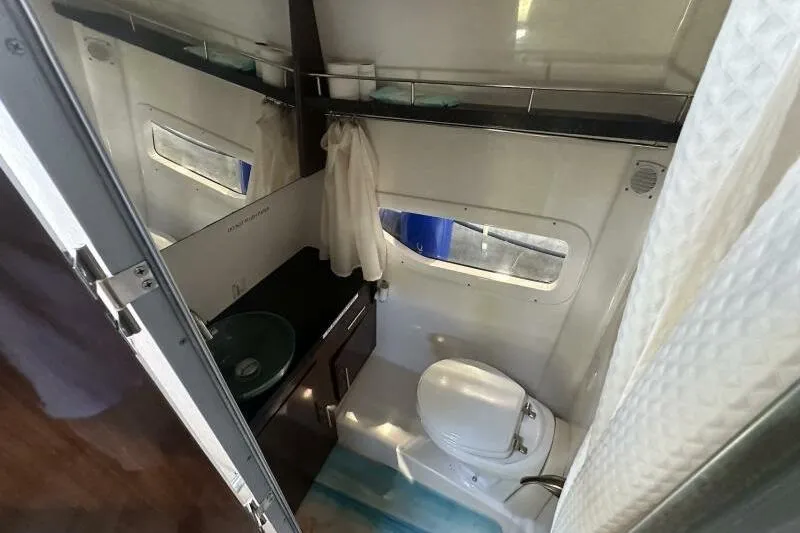 Panacea Yacht Photos Pics Bathroom interior of 2015 Regal 32 Express boat with toilet, sink, and window.