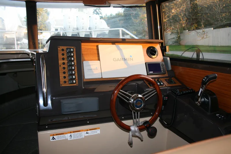 Little Toot Yacht Photos Pics 2019 Ranger Tugs R-27 helm with Garmin navigation system and wooden steering wheel.