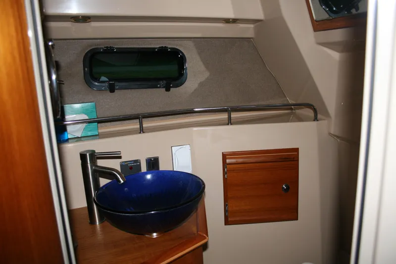 Little Toot Yacht Photos Pics 2019 Ranger Tugs R-27 boat bathroom with blue sink and wooden cabinet.